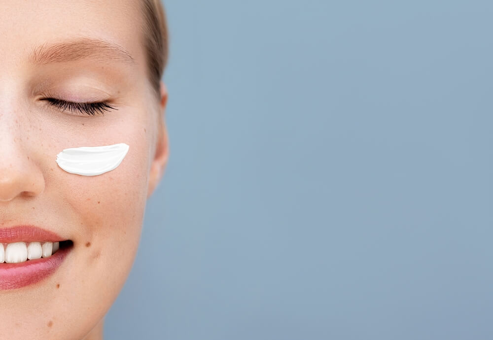 Skinimalism: Junge Frau mit Creme auf der Wange